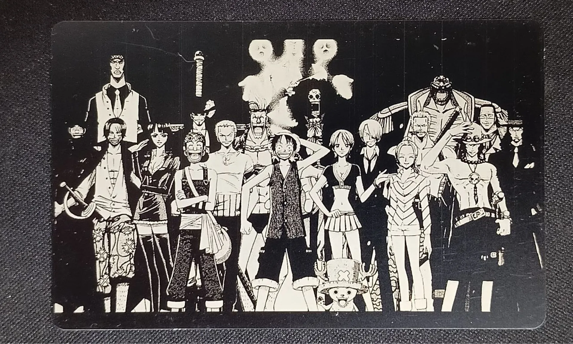 Четкая лазерная гравировка персонажей аниме One Piece на черном анодированном алюминии. Пример маркировки металла Wattsan.