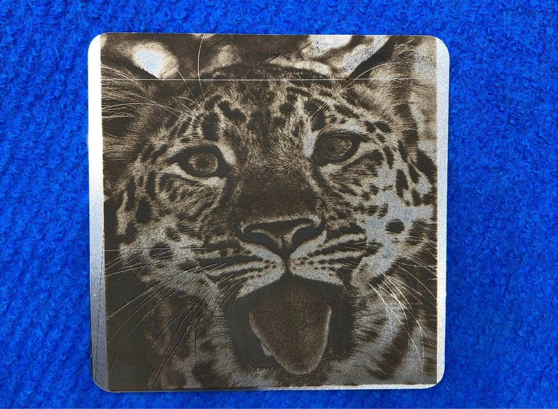 Детальная лазерная гравировка портрета леопарда на пластине из нержавеющей стали. Идеальный пример точной маркировки металла.