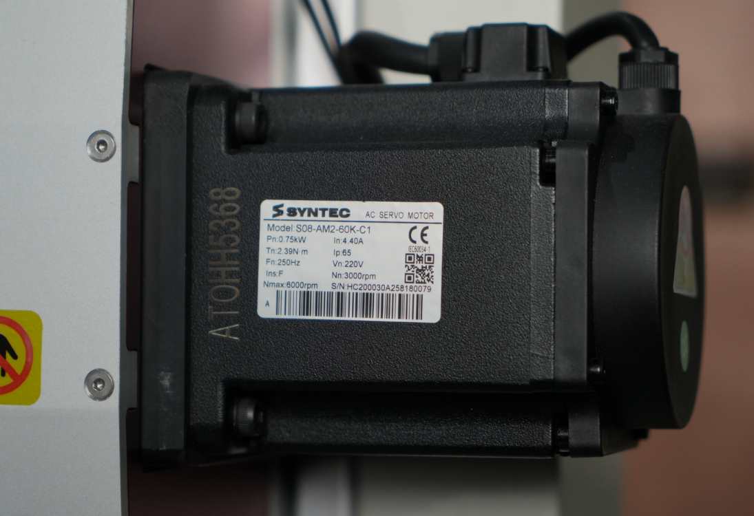 Шильдик с техническими характеристиками AC-серводвигателя Syntec (модель S08-AM2-60K-C1) для точного позиционирования.