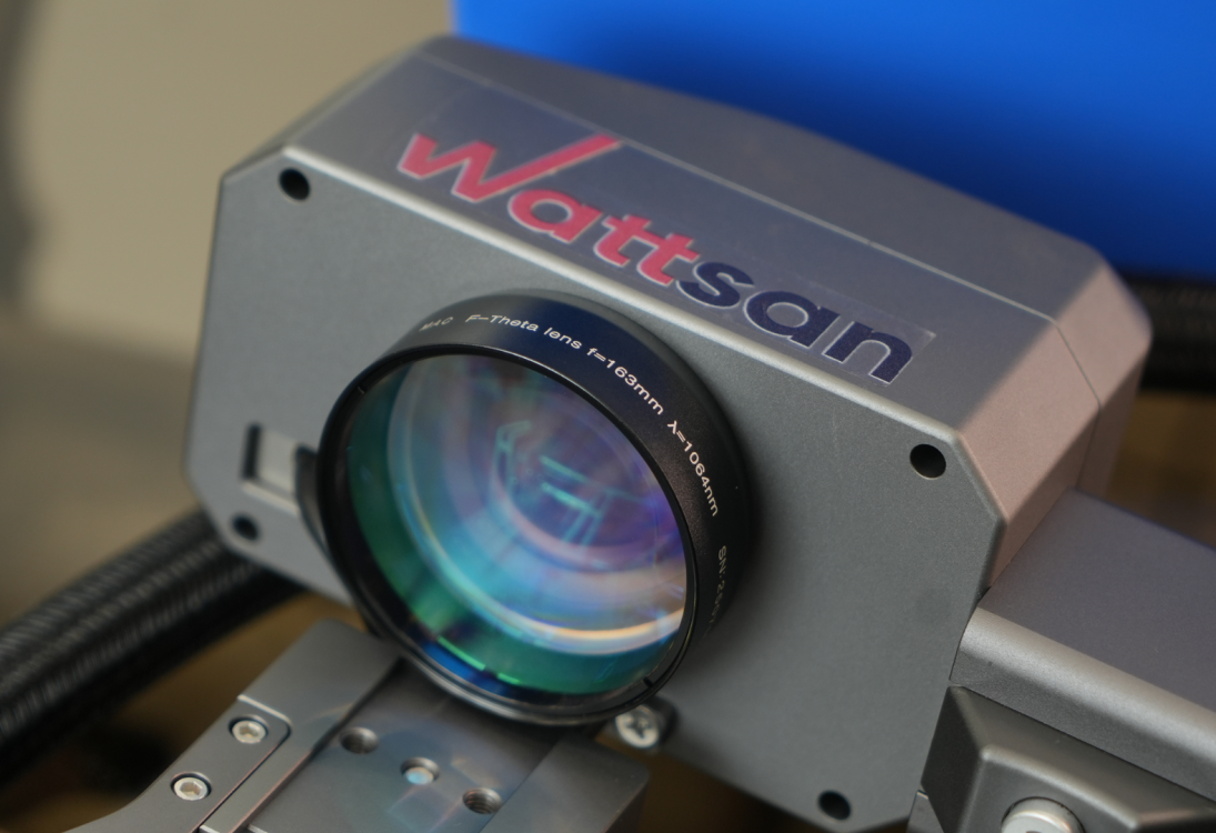 Крупный план линзы F-Theta (f=163mm, &lambda;=1064nm) на сканирующей головке лазерного маркера Wattsan FL HT.