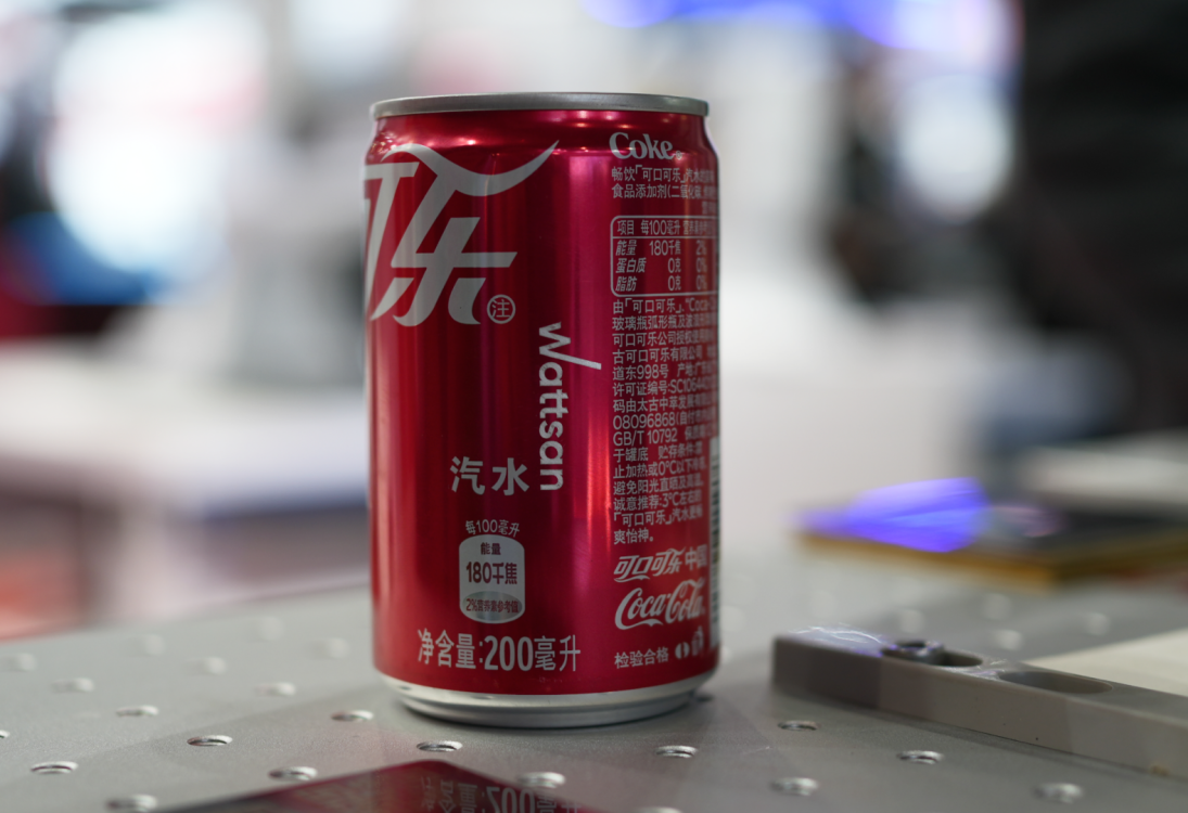 Красная банка Coca-Cola с кастомизацией "Wattsan" и китайским текстом, этикетка питания, на металлическом столе.